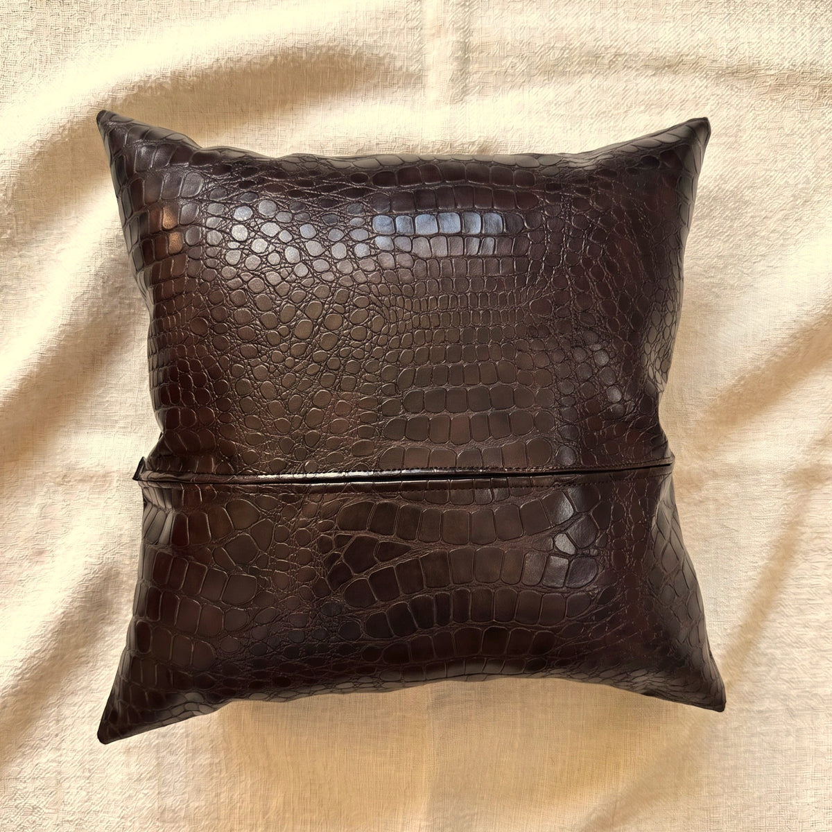 Angled view of Croc Espresso croc-embossed pillow cover