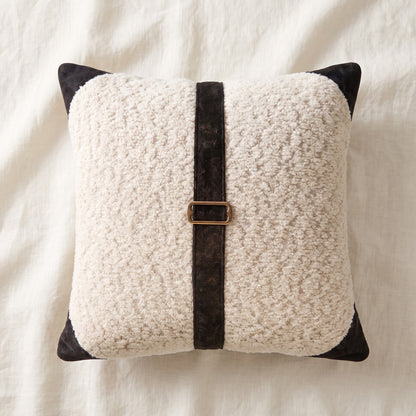White bouclé square pillow cover featuring a vertical black printed velvet band and rectangular bronze-tone buckle detail.