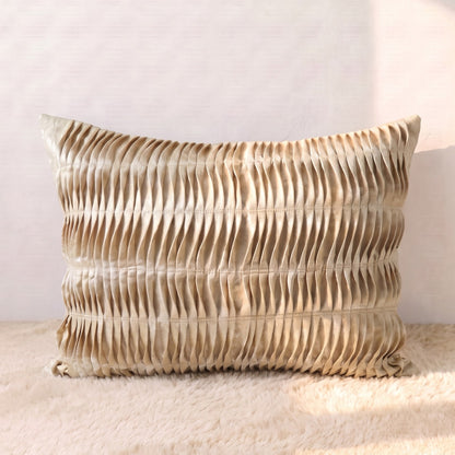 Rectangular champagne-gold jacquard lumbar pillow cover with dimensional pleated detailing across the front.
