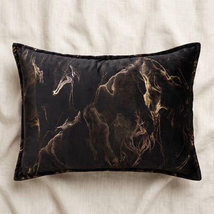 Rectangular black velvet lumbar pillow cover featuring a flowing gold abstract smoke pattern and coordinating piped border.
