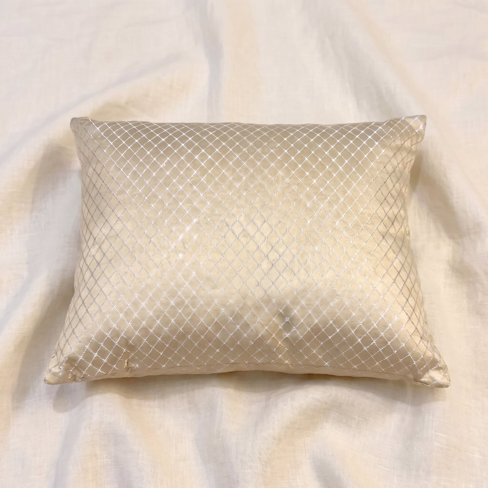 Angled view of a champagne-gold jacquard pillow cover showing the LUMBAR shape, corner construction, woven texture and subtle fabric sheen.
