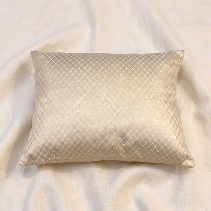 Angled view of a champagne-gold jacquard pillow cover showing the LUMBAR shape, corner construction, woven texture and subtle fabric sheen.
