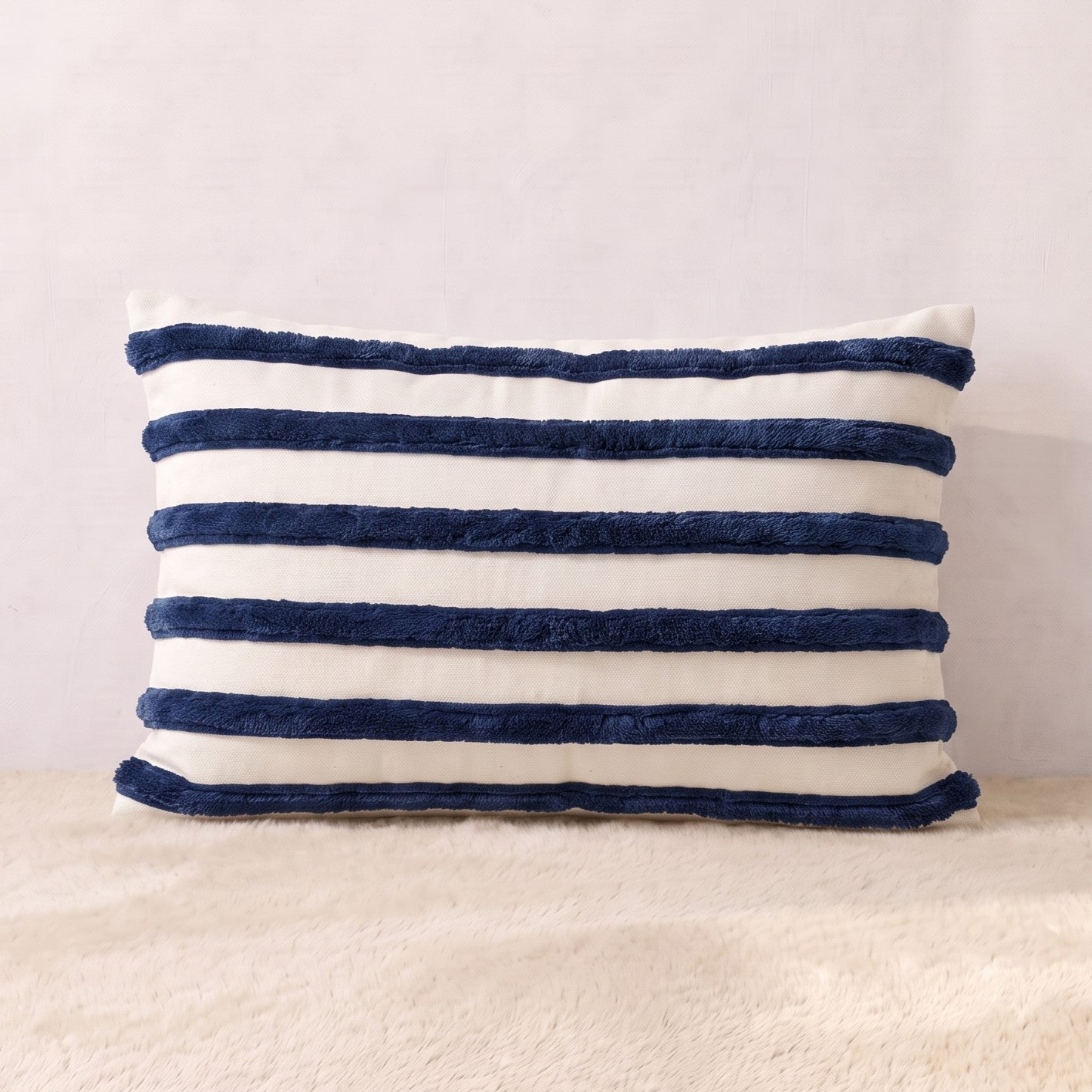 Rectangular ivory velvet lumbar pillow cover with multiple horizontal navy corduroy stripes across the front.

