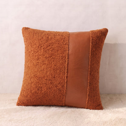 Square terracotta pillow cover combining textured curly bouclé with a smooth faux leather decorative panel.
