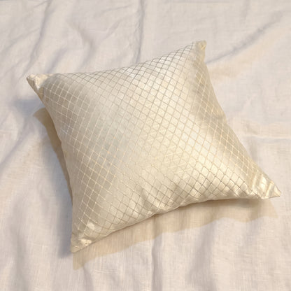 Square champagne-gold jacquard pillow cover with an all-over woven geometric diamond lattice pattern and softly reflective finish.
