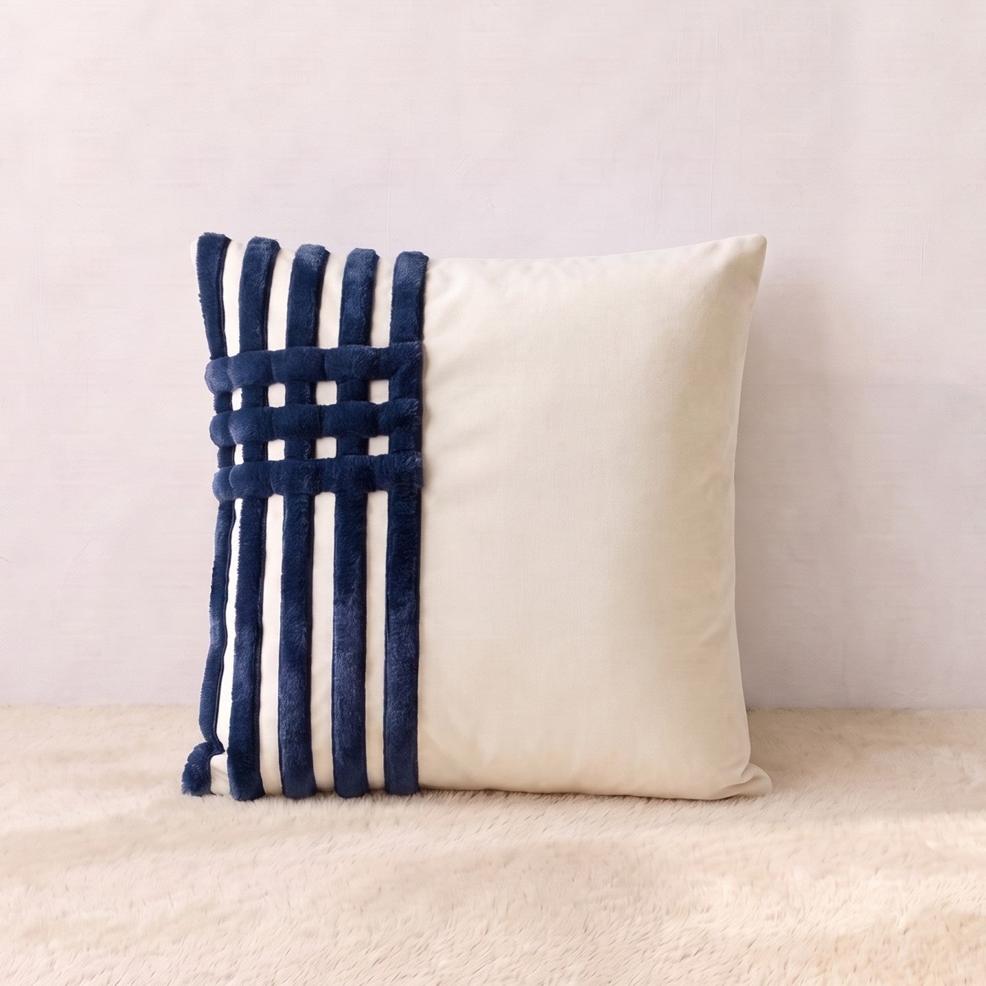 Ivory velvet square pillow cover with navy corduroy bands arranged in a structured linear design.
