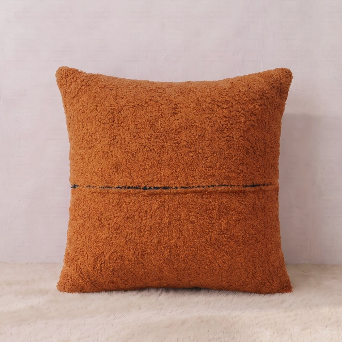 Back view of a terracotta bouclé pillow cover showing the textured fabric reverse and zipper closure.

