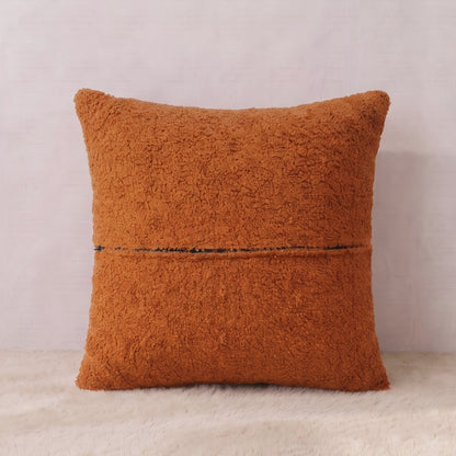 Back view of a terracotta bouclé pillow cover showing the textured fabric reverse and zipper closure.
