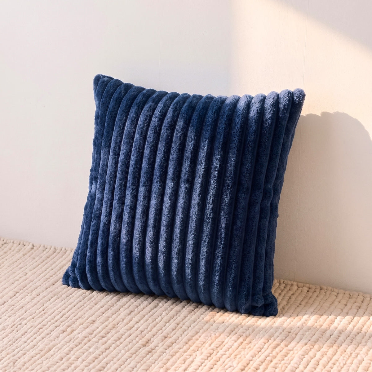 Square navy blue corduroy pillow cover showing its raised ribbed texture and solid color.
