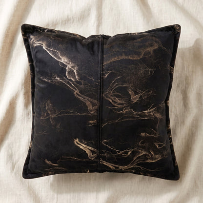 Back of a black and gold printed velvet square pillow cover showing the centered zipper closure.
