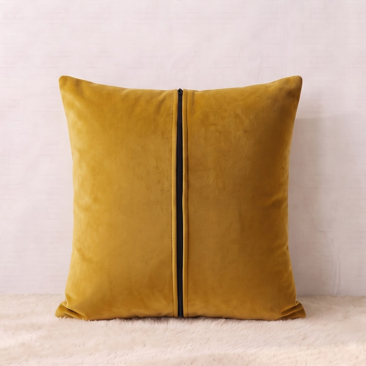 Back of a mustard-gold velvet pillow cover showing the plain velvet reverse and zipper closure.