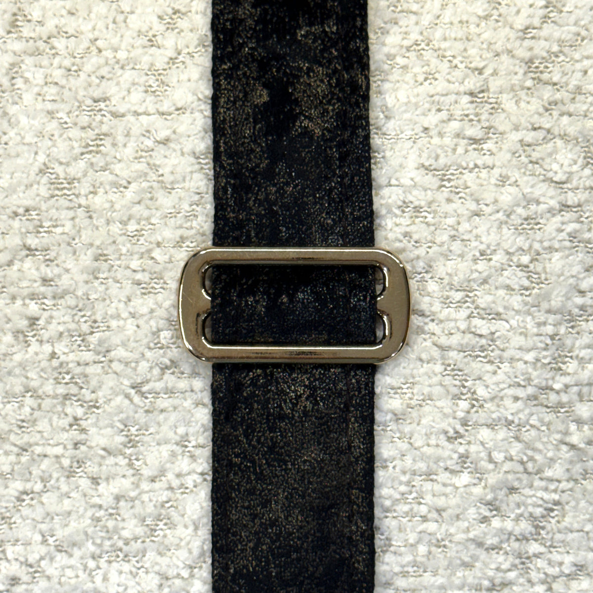 Close-up of Dream Cloud white texture, black trim and bronze buckle