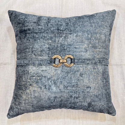 Blue-gray velvet square pillow cover with a matching velvet strap and decorative gold-tone double-ring hardware.