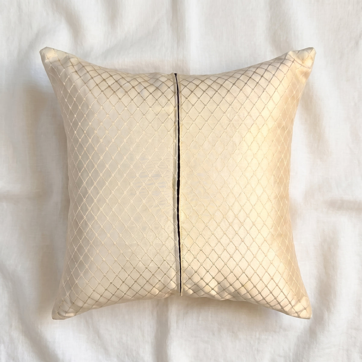 Back view of a champagne-gold jacquard pillow cover showing matching fabric on the reverse and the zipper closure.
